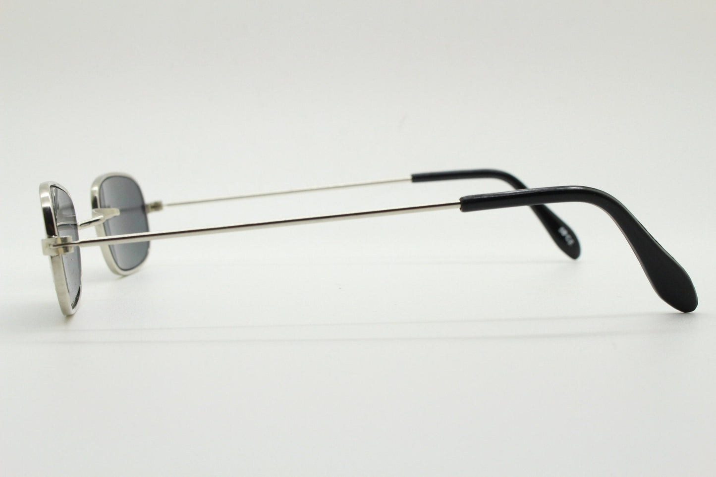 80s vintage rectangular low profile metal sunglasses. Minimal 60s mens mod design in silver chrome frame with grey lenses. NOS