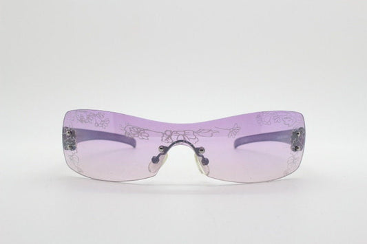 Y2K vintage visor sunglasses. Frameless 2000's purple wraparound mini mask shield design with light tone mono lens and flower print. 00s NOS