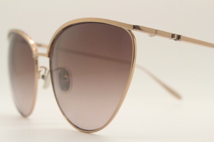 Carolina Herrera minimal cat eye sunglasses model SHN069 made in Italy. Women's  gold titanium cateye frame with brown lenses. Vintage NOS
