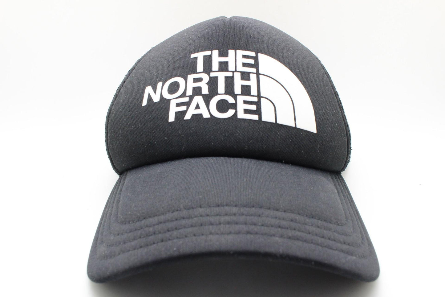 The North Face plain black baseball cap with big white spell out logo. Classic trucker style hat with fully adjustable back