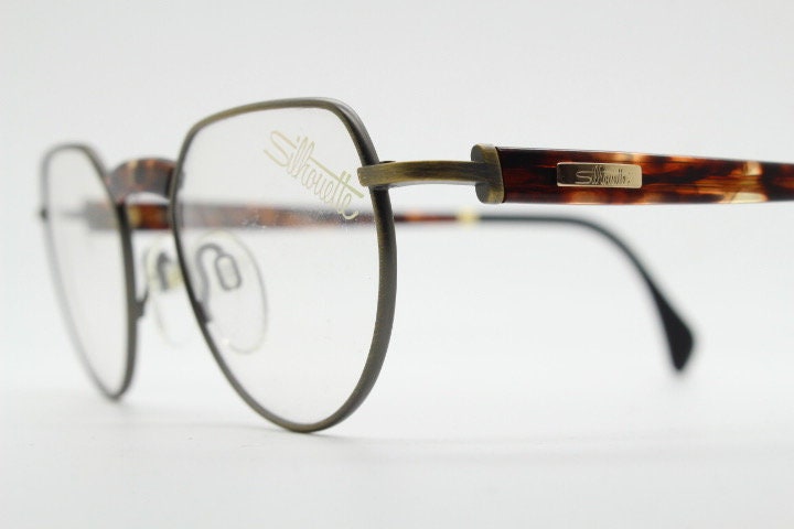 Silhouette vintage 90s flat top oval eye glasses made in Austria. Satin bronze optical frame with honey tortoise trim. Prescription RX