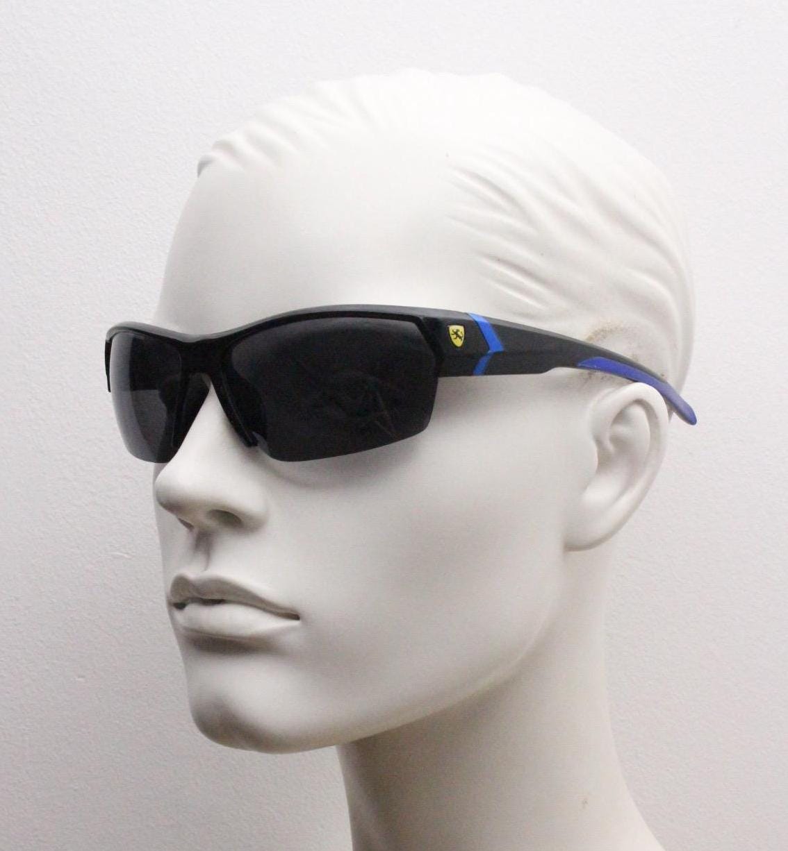 A pair of black sunglasses with blue accents, displayed on a white mannequin head.