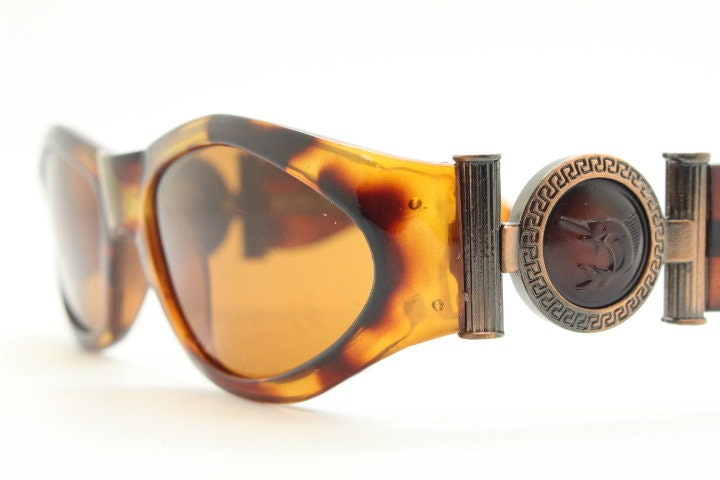 90s vintage oval sunglasses. Low profile transparent tortoise frame with massive bronze metal arm crests BNWT. Unused NOS
