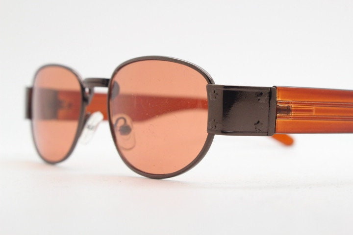 90s vintage low profile sunglasses. Brown chrome frame with thick transparent amber arms and orange lenses. Unused. BNWT