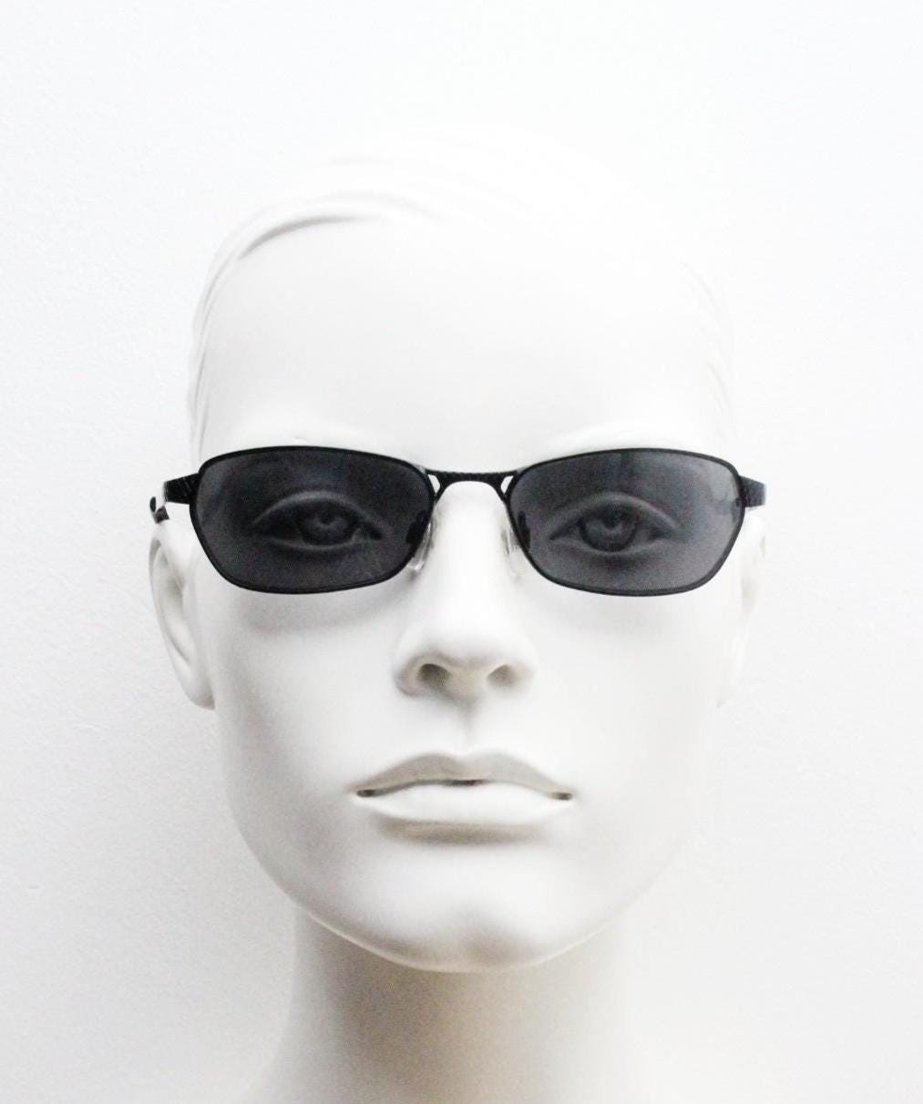 90s vintage wraparound sunglasses. Black satin finish on rectangular frame with unassuming style details. 2000's. Y2K. Unused NOS bug eye