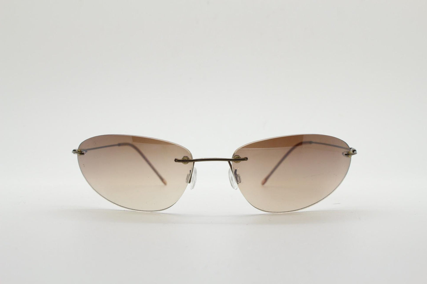 90s vintage frameless oval wraparound sunglasses. Minimal curved almond shaped lenses with brown chrome arms. 2000s NOS. Matrix cosplay