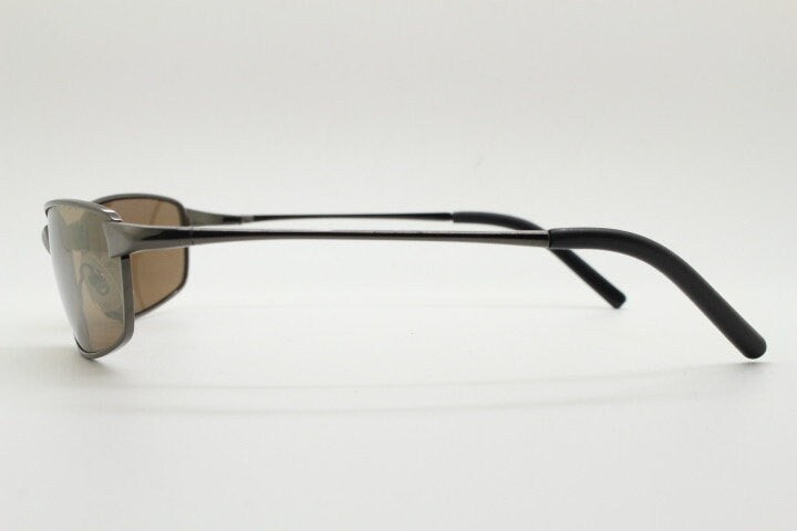 90s vintage curved rectangular sunglasses. Solid metal low profile frame in brown chrome with slightly mirrored lenses. 2000's. Y2K NOS