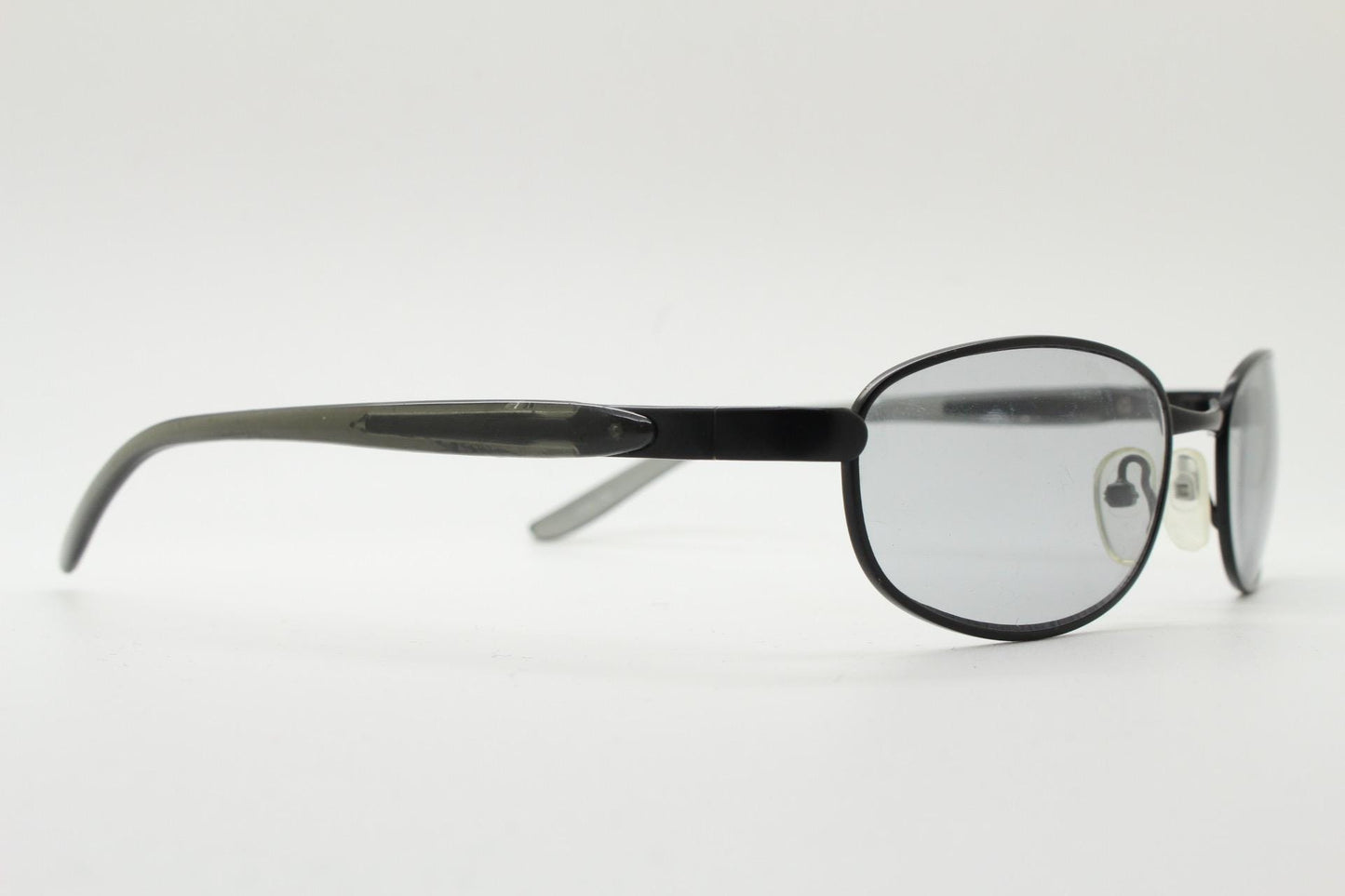90s vintage oval small bug eye sunglasses. Curved black satin finish metal frame with transparent grey arms and light tone lenses. NOS