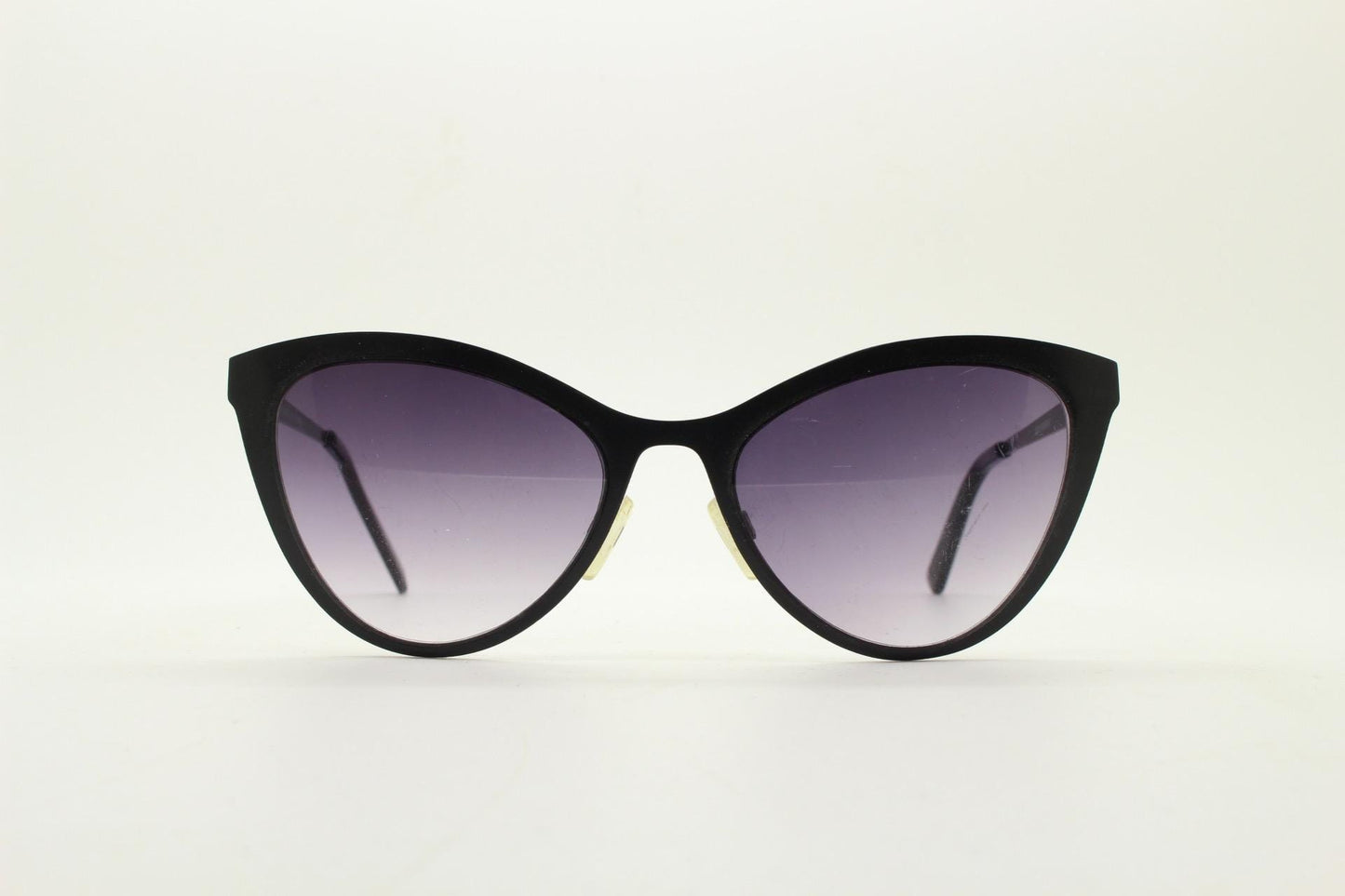 Vintage pointed cat eye sunglasses. Flat metal frame in a satin finish encasing smoky grey graduating lenses. Womens cateye