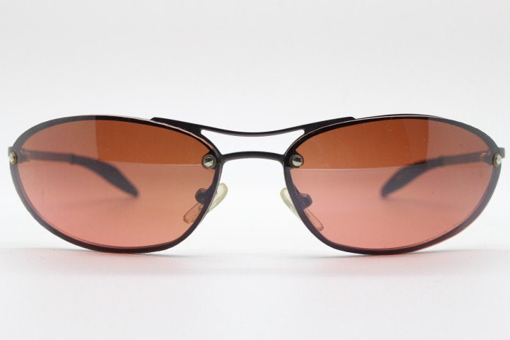 Y2K vintage oval sunglasses. Satin finish grey metal frame with amber curved almond bug eye lenses and straight arms. 2000's. NOS