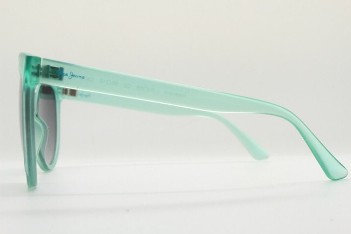 Pepe Jeans big cat eye sunglasses. Transparent chunky aquamarine frame with contrasting black graduating lenses. Womens vintage cateye