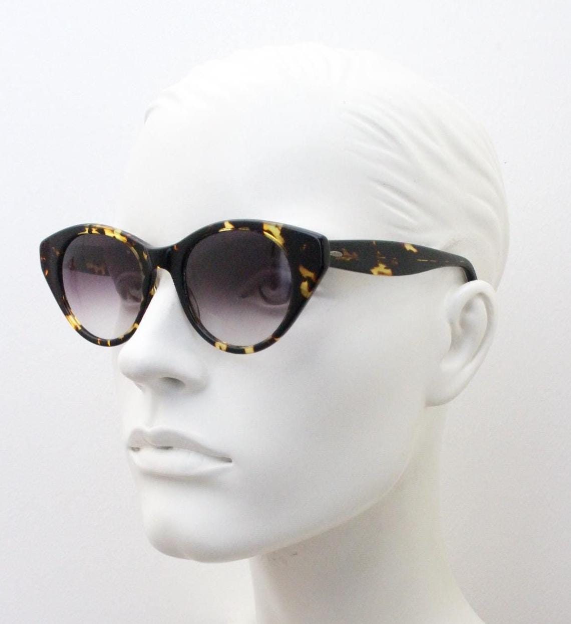 Barton Perreira subtle cat eye sunglasses model kismet. Honey tortoise acetate frame with cropped sides and graduating lenses