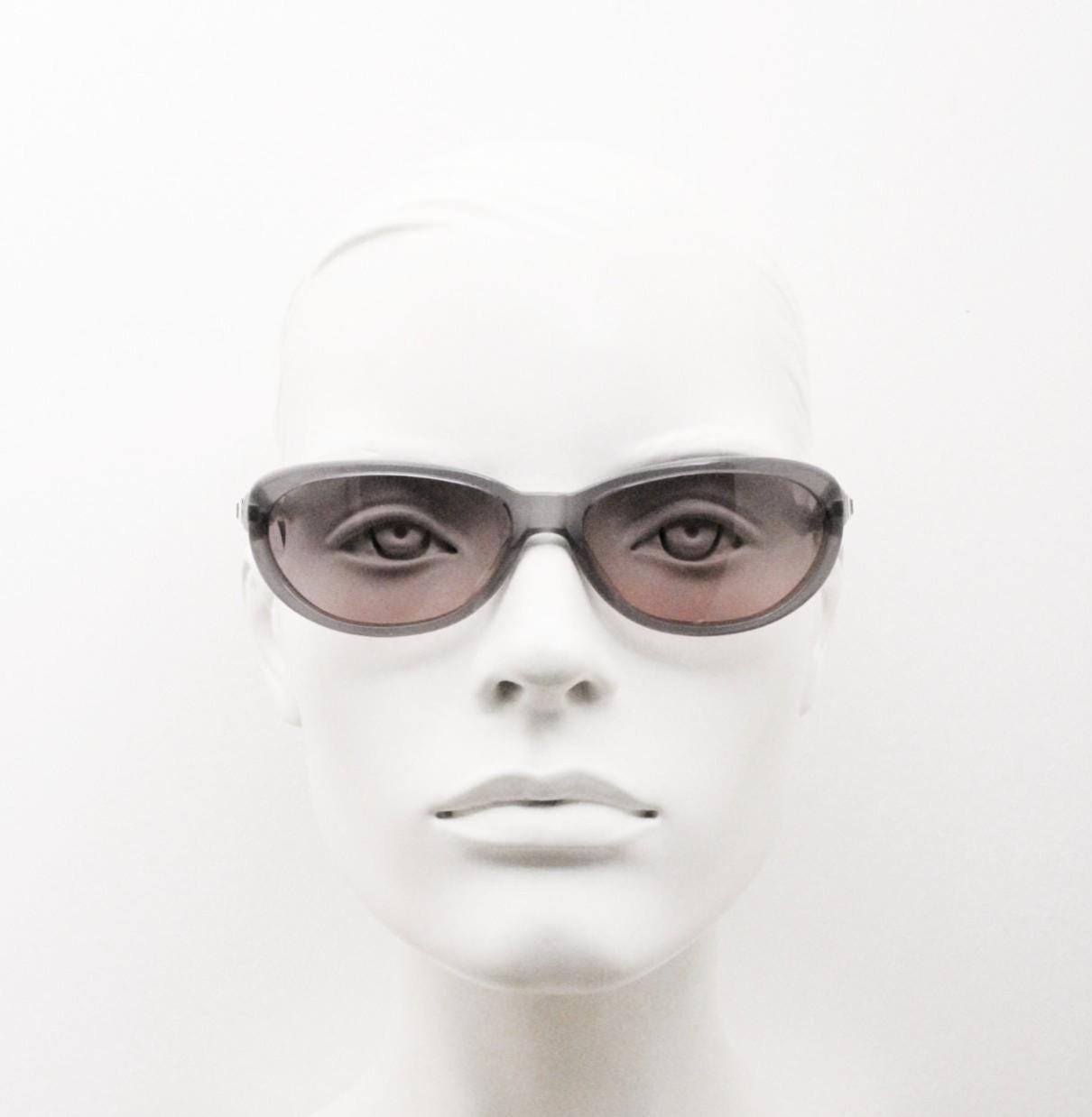 Genny 90s vintage oval cat eye sunglasses made in Italy. Transparent dark grey acetate frame with pink lenses. Womens NOS cateye. BNWT