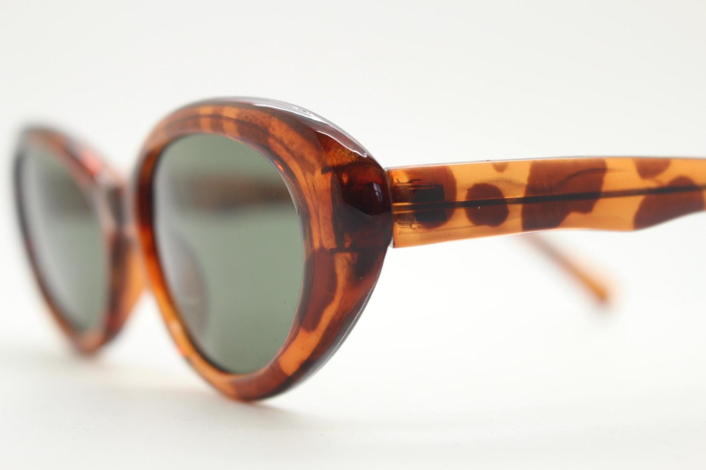Vintage 90s oval cat eye sunglasses. Vibrant amber tortoise quality acetate frame in neat proportions with green lenses. Womens NOS