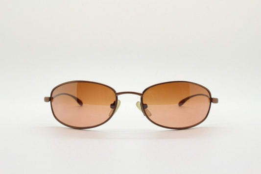 Y2K vintage oval small bug eye sunglasses. Curved copper satin finish metal frame with slender arms. Unused 2000s NOS