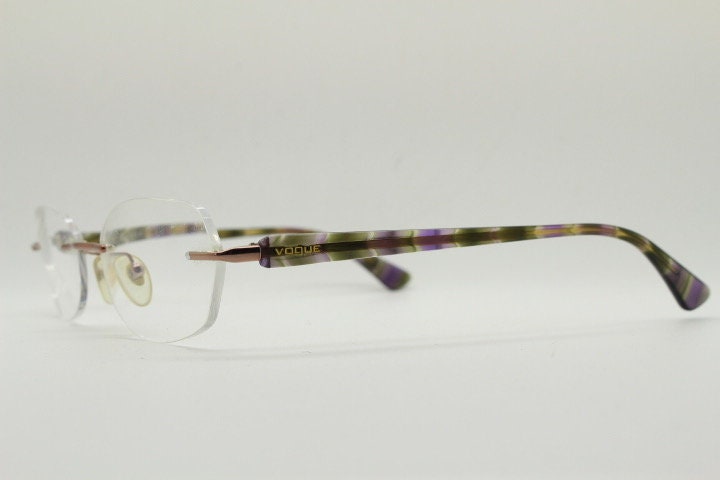 Vogue vintage frameless oval eye glasses. Transparent acetate arms with purple and green tones. Minimal Prescription RX Optical frame