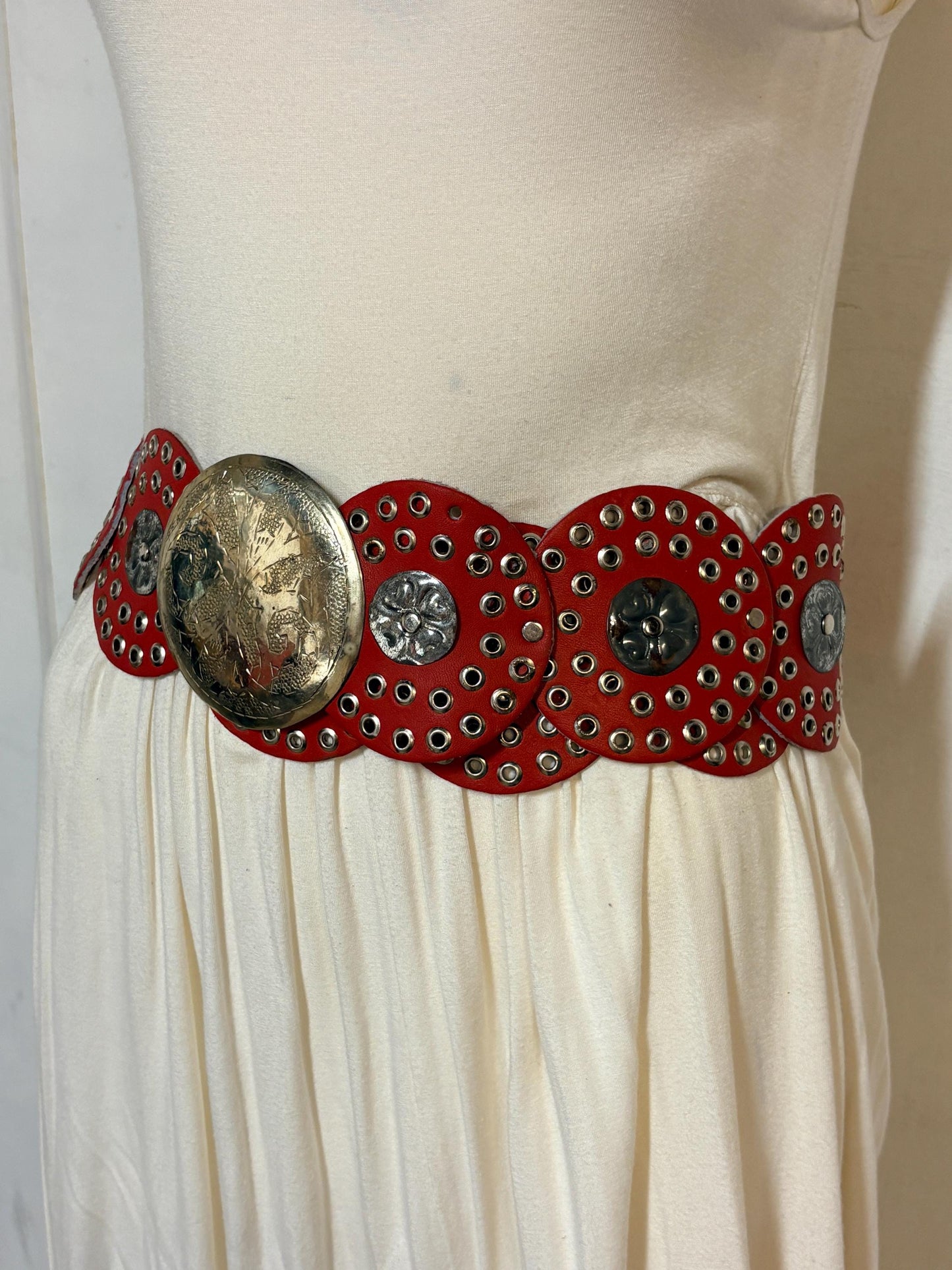 80s vintage womens huge red leather circles belt. Versatile statement piece with holed studs, metal discs and big 'shield' buckle. NOS