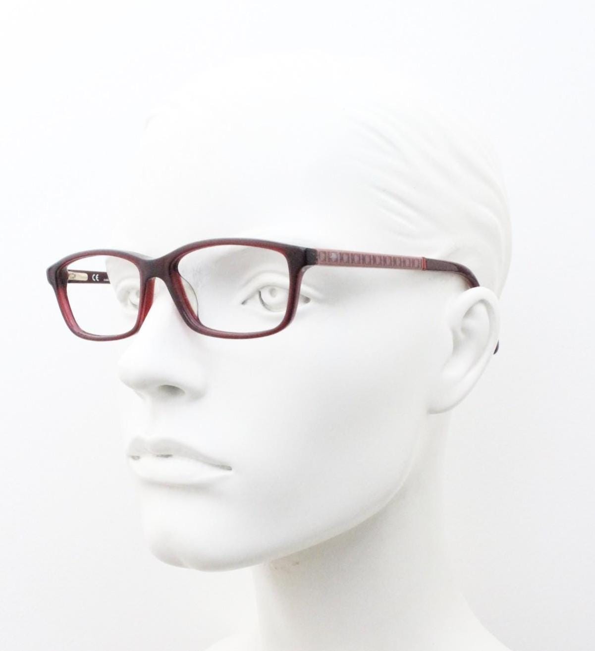 Carolina Herrera rectangular low profile eye glasses. Dark pink acetate optical frames with tasteful arm logo. Prescription RX eyeglasses