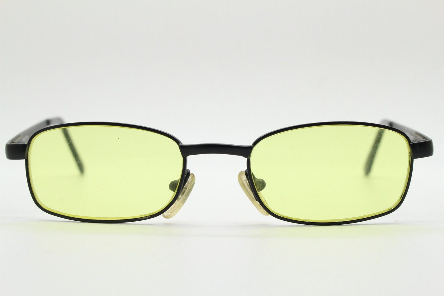90s vintage small rectangular sunglasses. Minimal plain black matt metal frame with bright yellow lenses. Steampunk. Micro