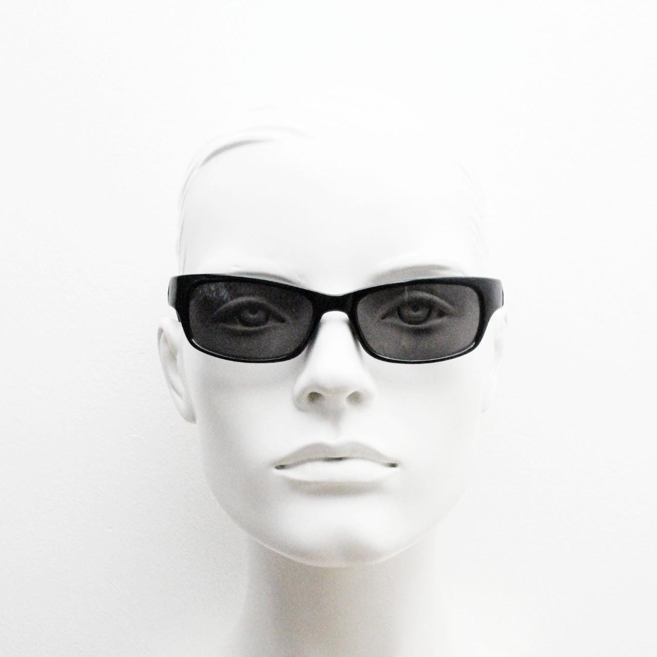 90s vintage curved wraparound sunglasses. Aerodynamic low profile plain black gloss curved cat eye frame. Minimal shield design. NOS