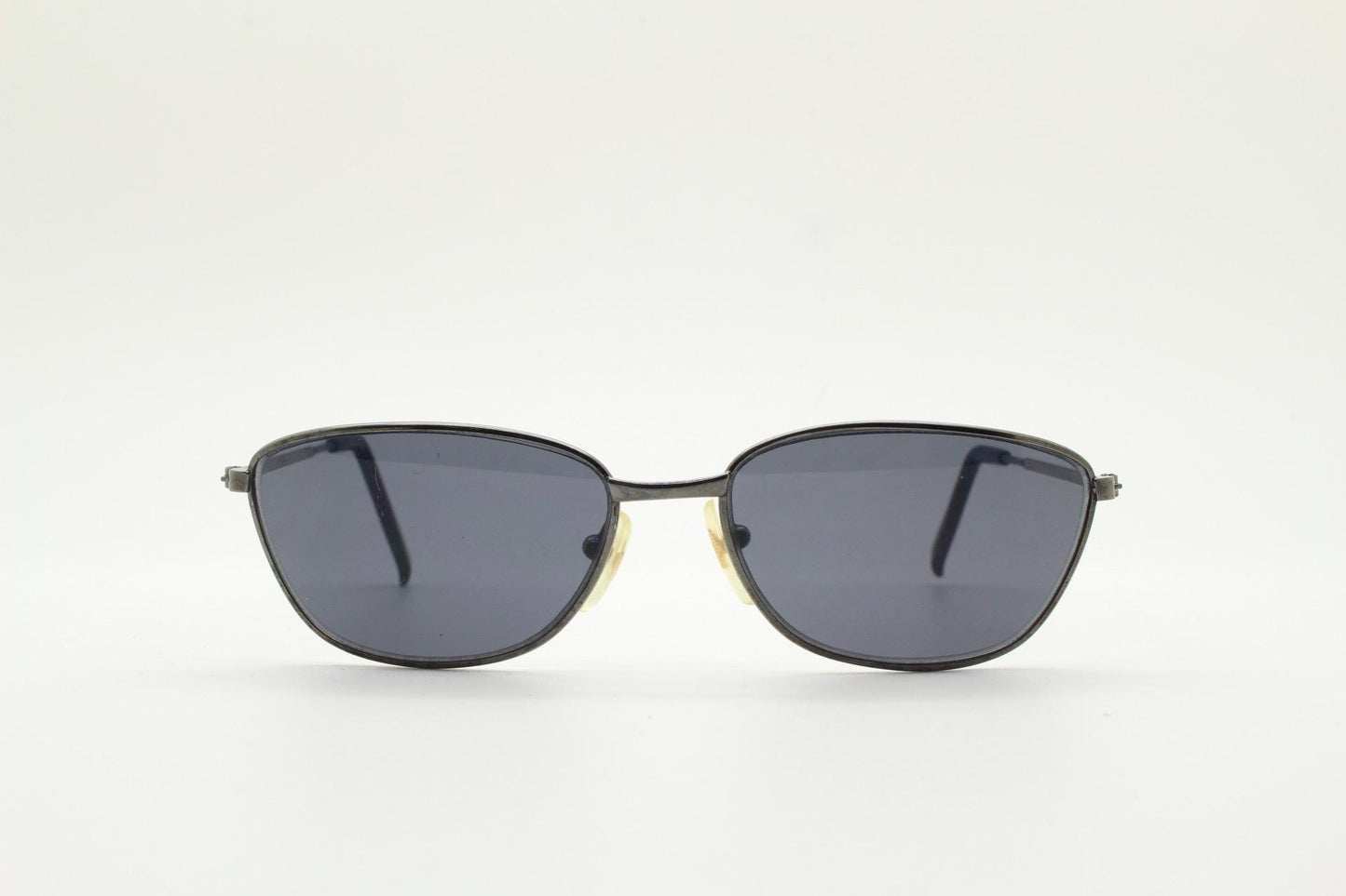 90s vintage angular pointed sunglasses. Minimal grey chrome metal frame with embossed patterned arms. Subtle cat eye. NOS