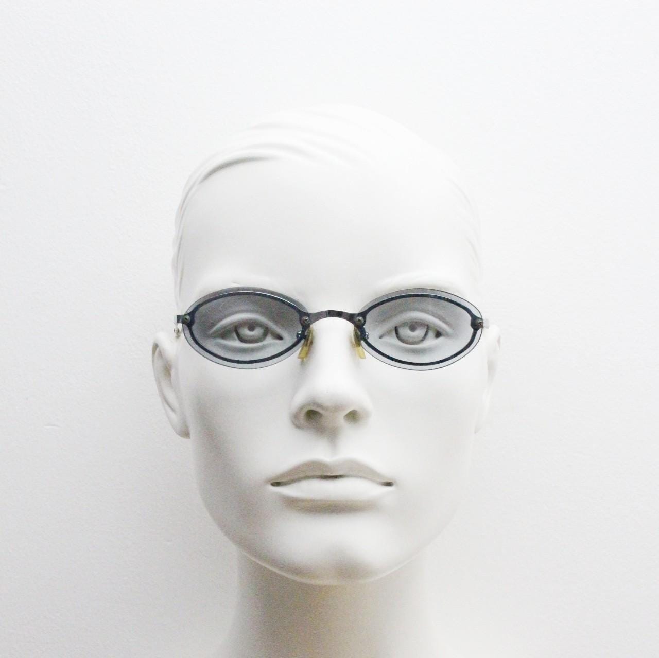 90s vintage small oval sunglasses. Minimal silver chrome metal frame with overlapping light tone grey lenses. Micro. Steampunk