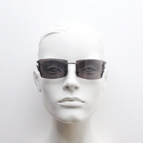 Y2K vintage wraparound sunglasses. Dynamic frameless shield design in gunmetal grey with slight mirror glaze rectangular lenses. 2000's NOS