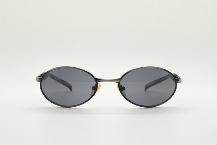 90s vintage small oval  bug eye sunglasses. Brushed bronze finish frame with transparent grey arms. Y2K. 2000s. Unworn NOS