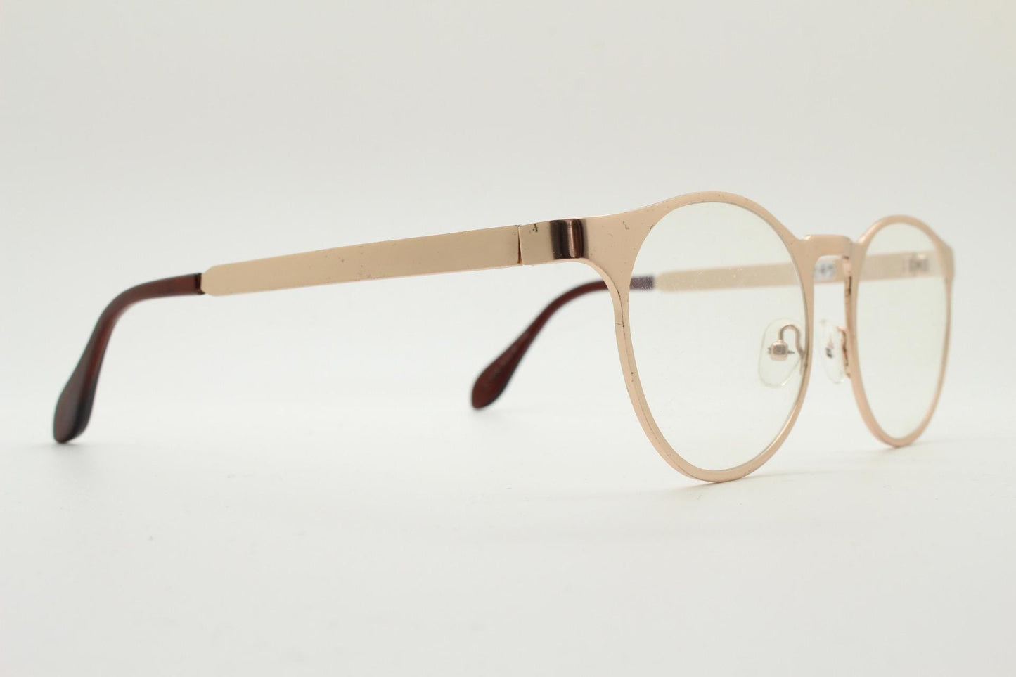 Y2K round metal eye glasses with pointed corners. Solid flat shiny golden frame with clear lenses.