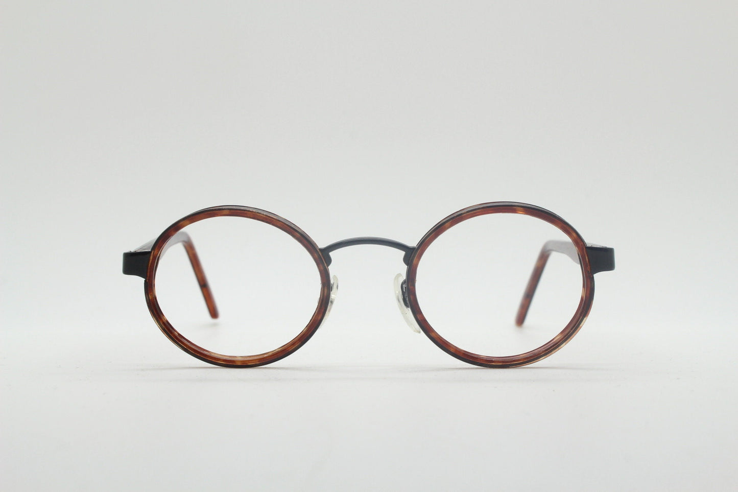 90s vintage oval glasses. Minimal slim black optical frame encasing tortoise inserts. 40s, 50s style prescription eyeglasses. RX spectacles
