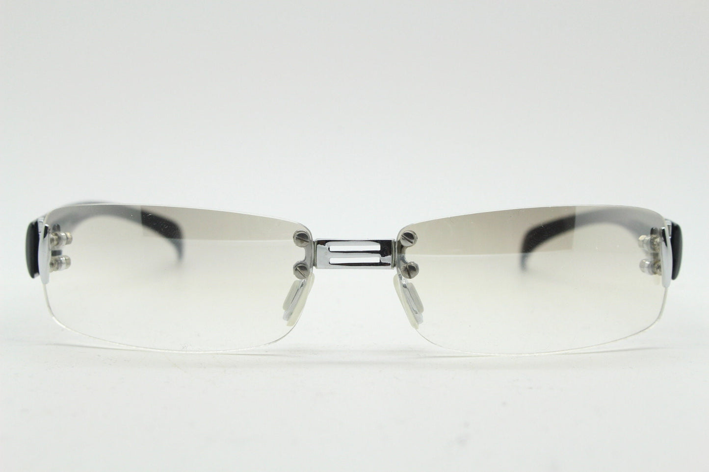 Y2K vintage frameless sunglasses. Silver chrome trim with patterned arms and extra light tone graduated curved mirror lenses. 2000's. 90s