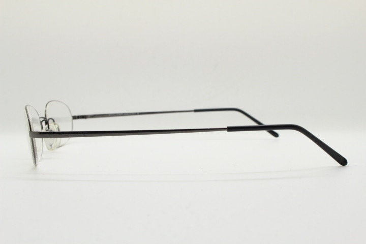 Police 90s vintage oval half rim eye glasses made in Italy. Minimal lightweight optical frame in gunmetal grey. Prescription RX Spectacles