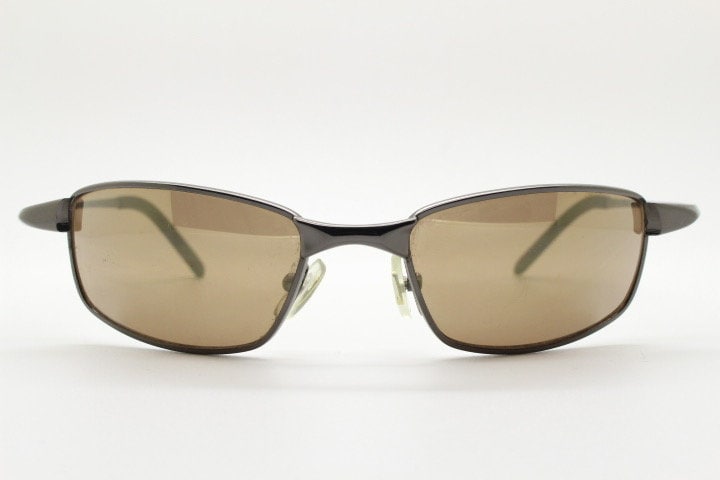 90s vintage curved rectangular sunglasses. Solid metal low profile frame in brown chrome with slightly mirrored lenses. 2000's. Y2K NOS