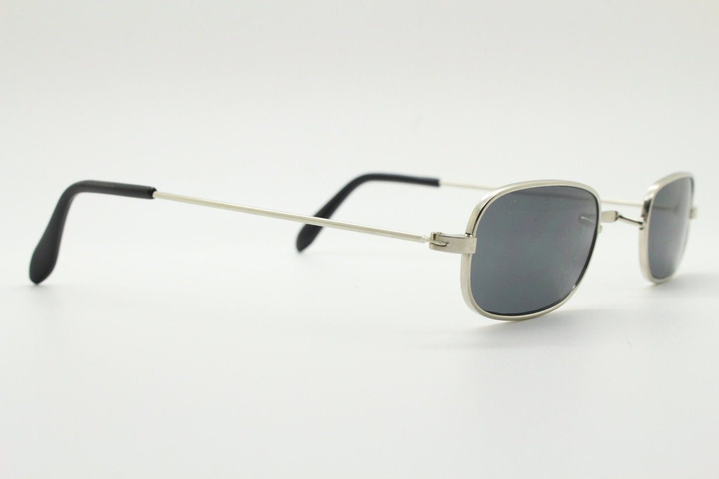 80s vintage rectangular low profile metal sunglasses. Minimal 60s mens mod design in silver chrome frame with grey lenses. NOS