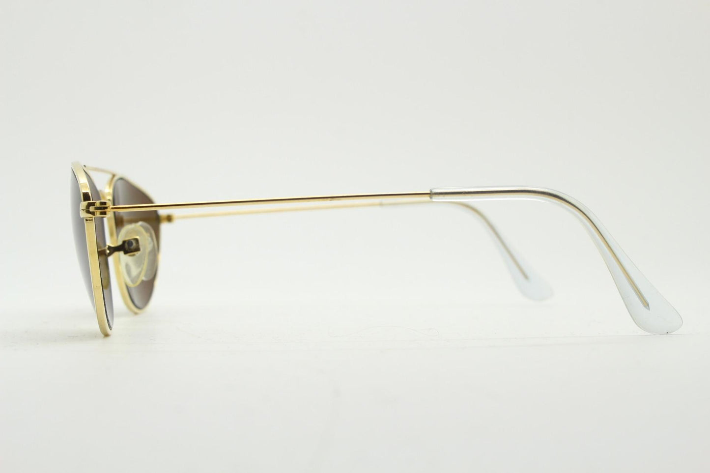 90s vintage minimal triangular sunglasses. Slim gold frame with plain brown lenses. Small modified aviator design. NOS
