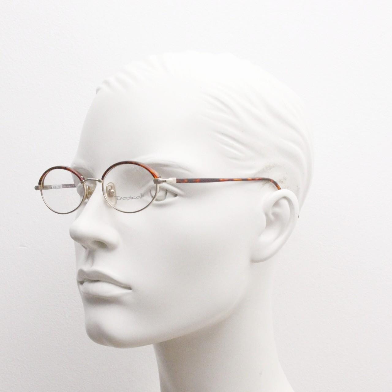 90s vintage small oval eye glasses by Tropical. Minimal gold optical frames with tortoise arms and brows. Prescription RX spectacles. NOS