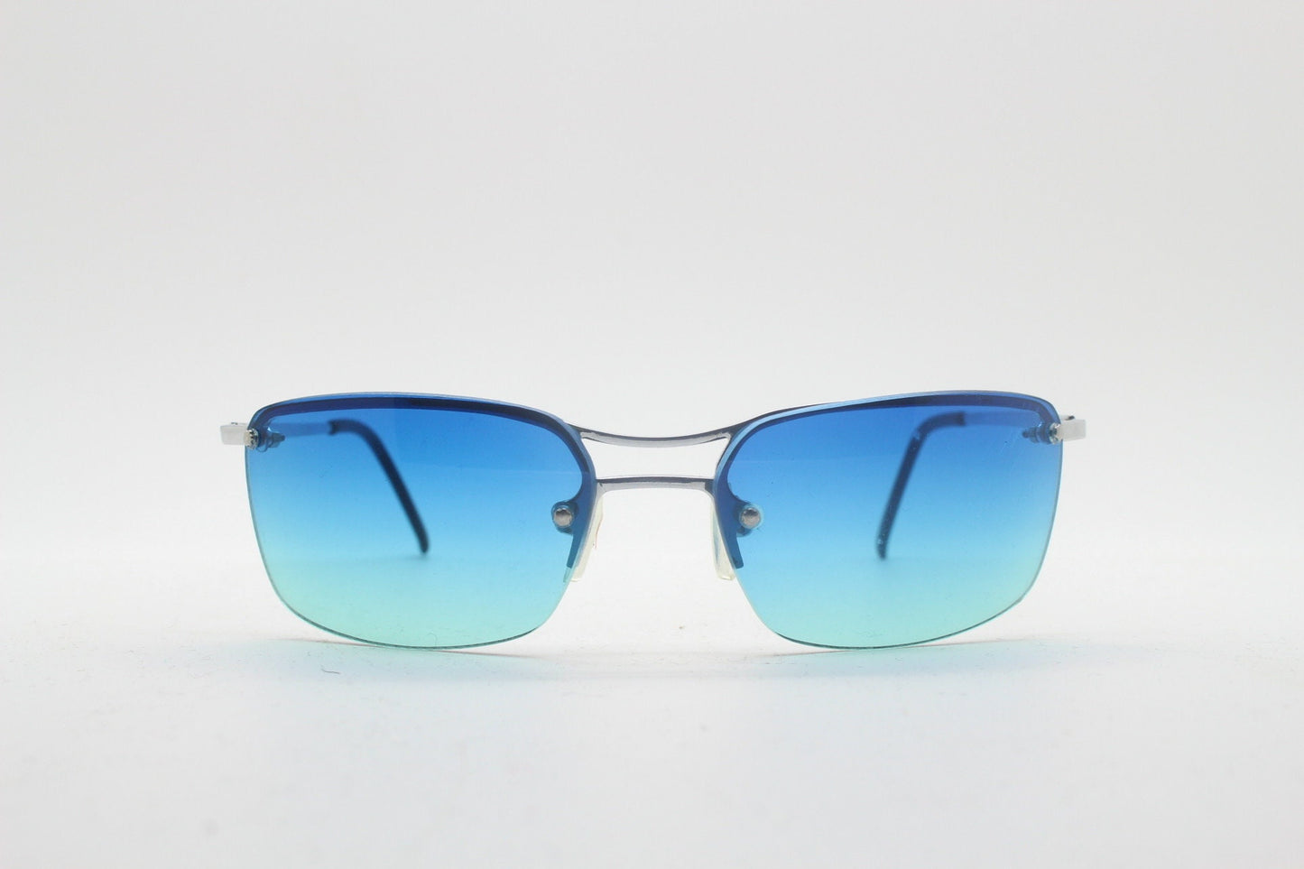 Y2K vintage visor sunglasses. Half frame wraparound shield design with light tone graduating turquoise to aquamarine lens. 2000's. 90s. NOS