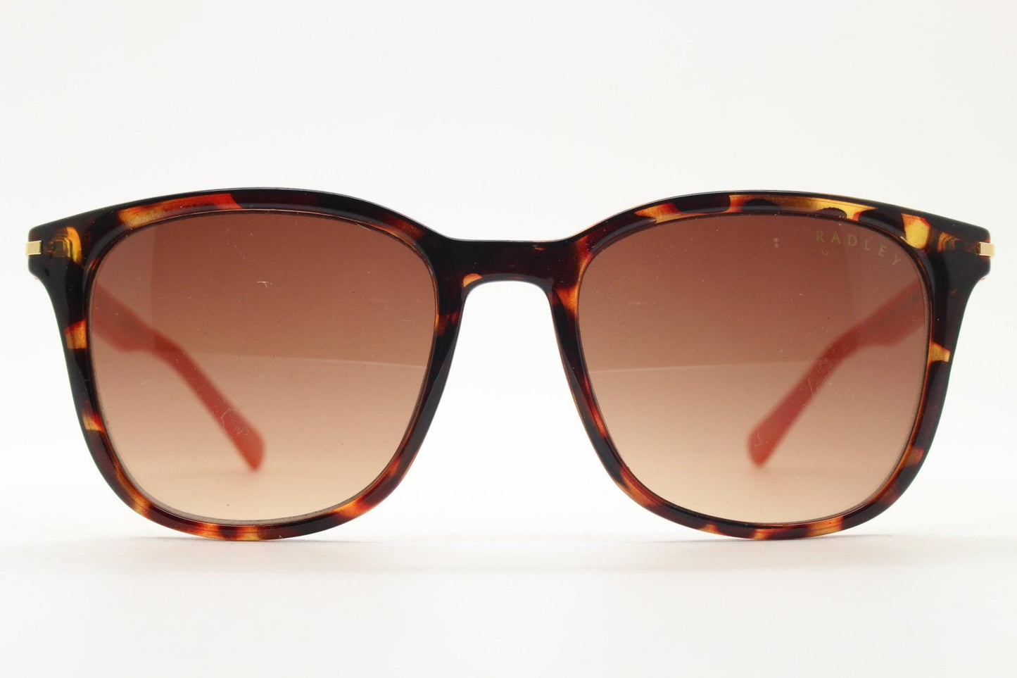 Modified wayfarer design sunglasses by Radley. Tortoise front with bright orange arms and Havana brown lenses. Vintage. Unused NOS