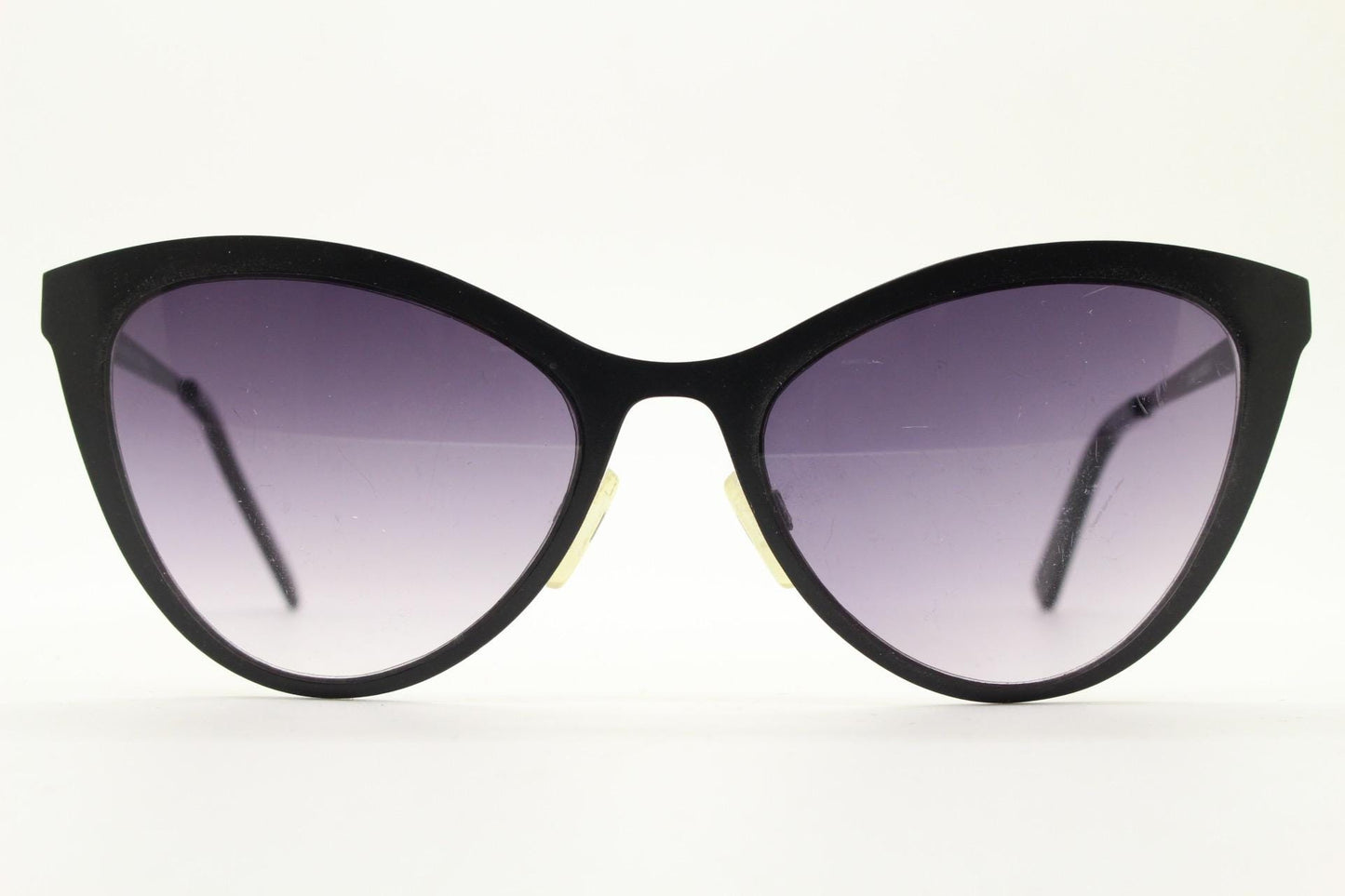 Vintage pointed cat eye sunglasses. Flat metal frame in a satin finish encasing smoky grey graduating lenses. Womens cateye