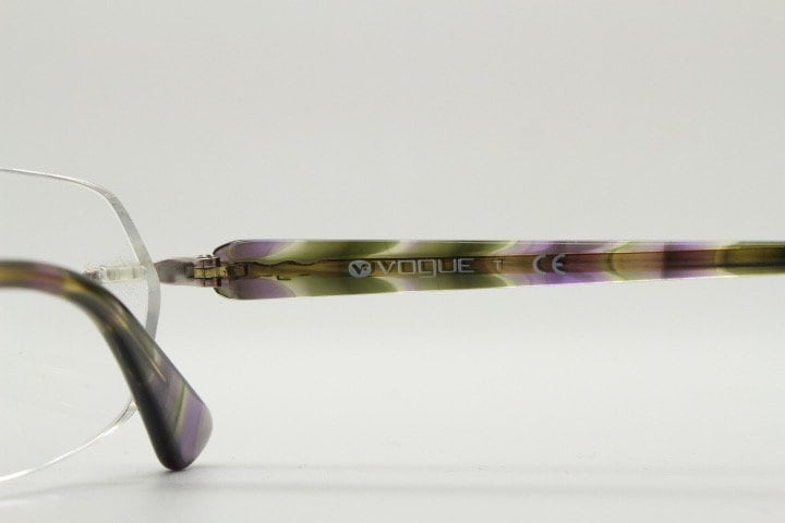 Vogue vintage frameless oval eye glasses. Transparent acetate arms with purple and green tones. Minimal Prescription RX Optical frame