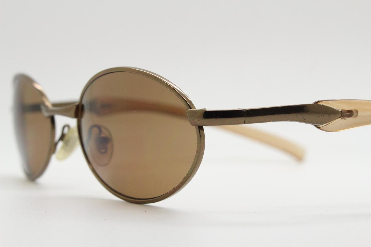 90s vintage small oval bug eye sunglasses. Minimal brown chrome finish metal frame with transparent curved arms. Y2K. Unused NOS