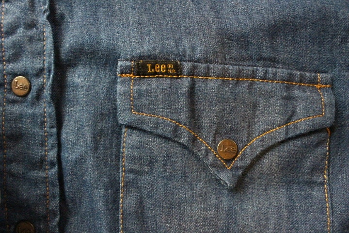 LEE 70s vintage short sleeve mens shirt. Blue denim western design with yolked pockets and back, epaulettes and brass popper buttons. NOS