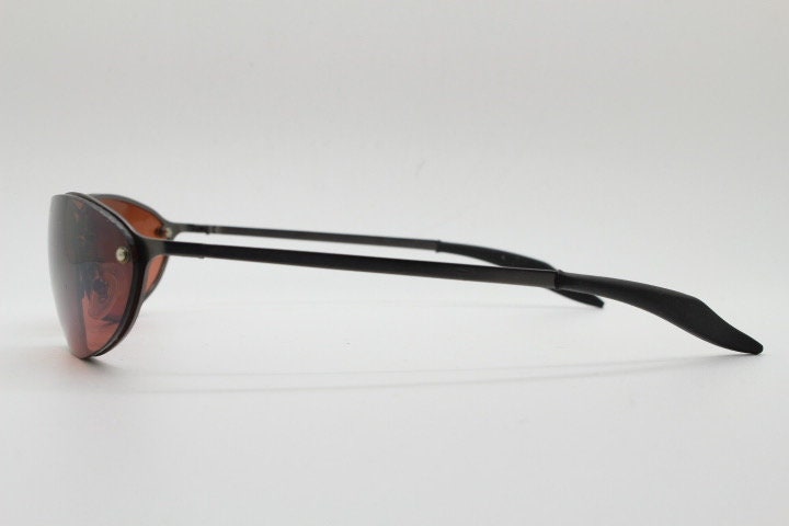 Y2K vintage oval sunglasses. Satin finish grey metal frame with amber curved almond bug eye lenses and straight arms. 2000's. NOS