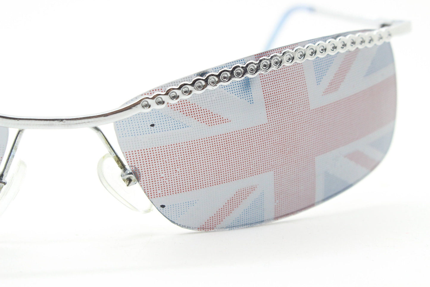90s vintage half frame Union Jack sunglasses. Curved lens suspended on a sparkling chrome brow. Unused NOS. Brit pop girl power