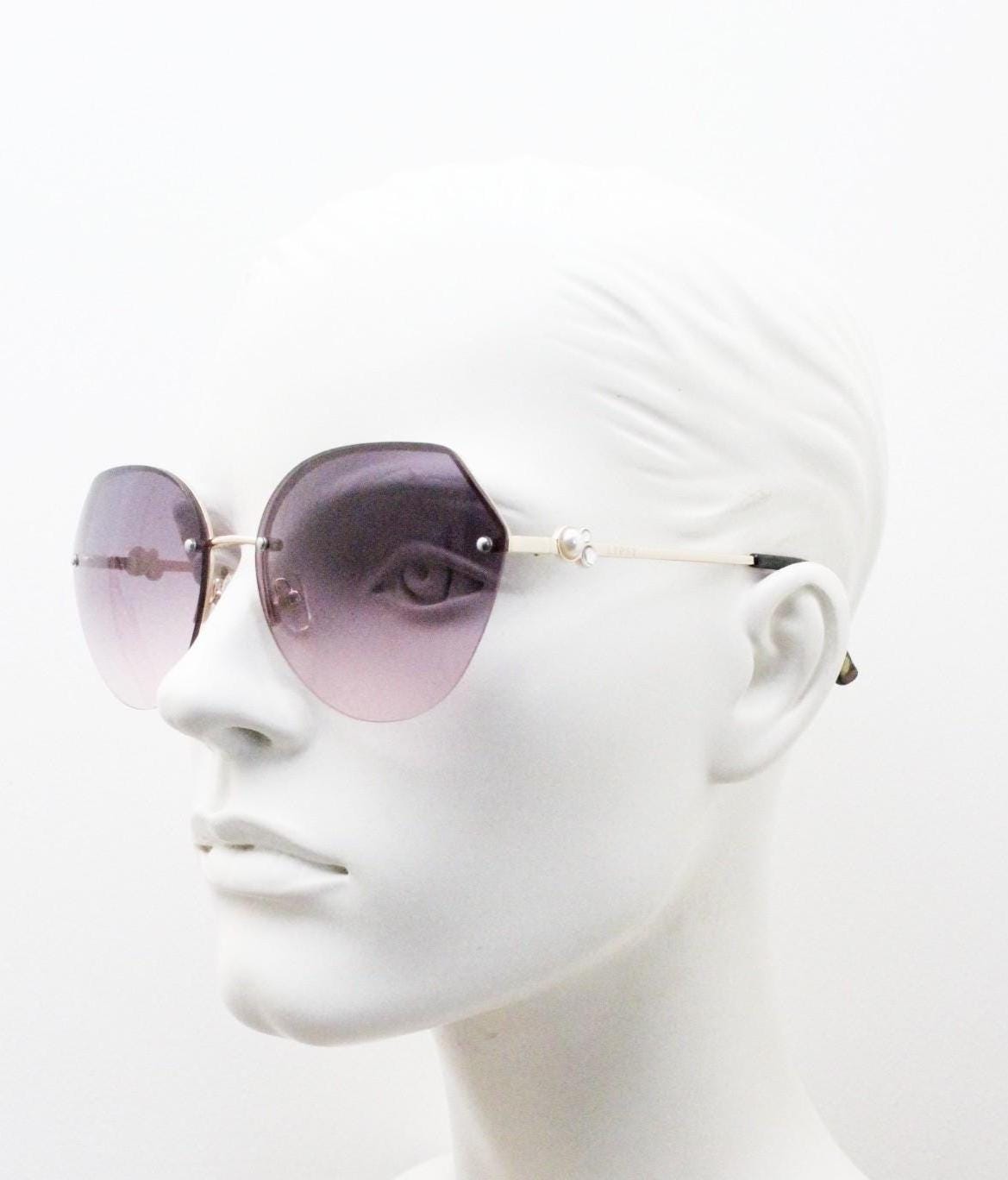 Large rimless sunglasses with dynamic angular grey to pink  graduating lenses. Women's 80s vintage style half frame with gold arms