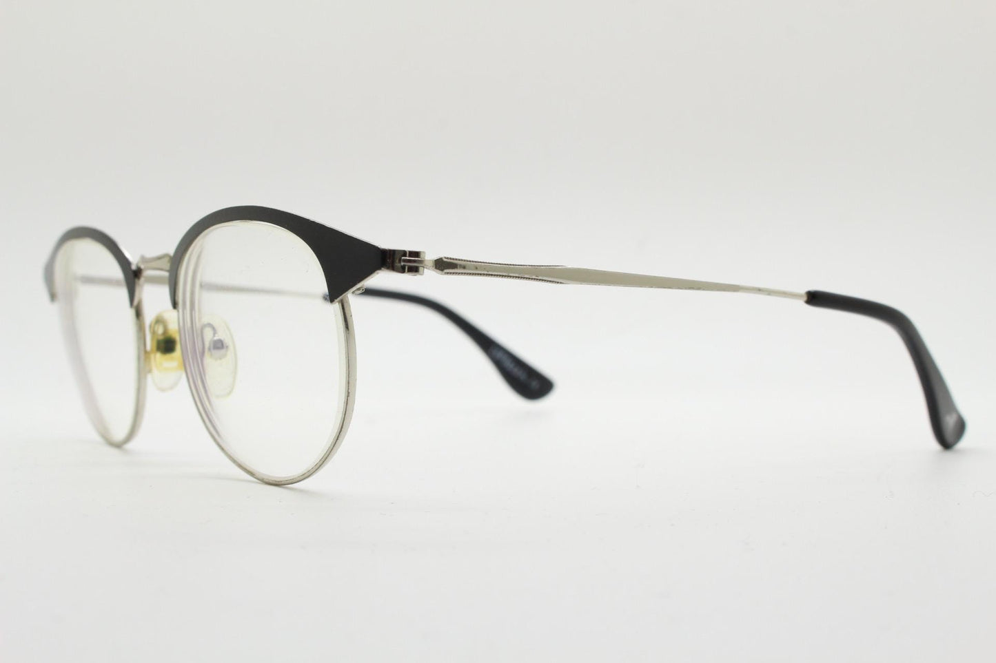 Lupo and Co round eye glasses with pointed corners. Flat metal silver optical frames with black browline. Prescription eyeglasses. RX