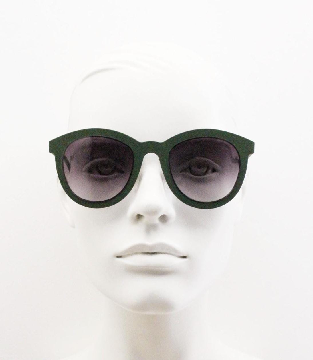 Round vintage cat eye sunglasses. Green flat metal frame in a slightly rubber finish that encases the lenses. Womens 2000s modified cateye