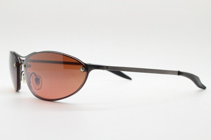 Y2K vintage oval sunglasses. Satin finish grey metal frame with amber curved almond bug eye lenses and straight arms. 2000's. NOS