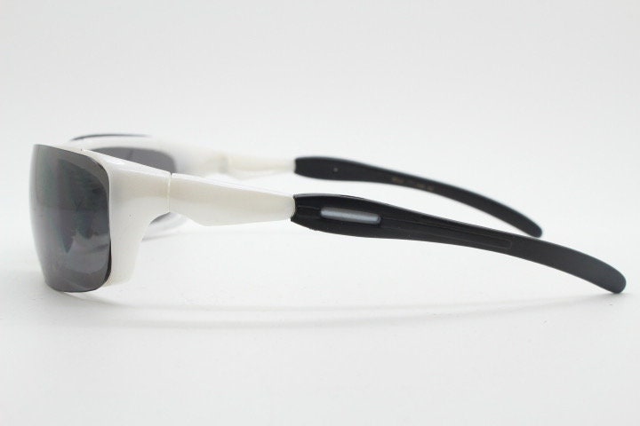 Y2K vintage visor sunglasses. Black and white superhero style sport shield with curved black lenses. Aerodynamic wrap around. NOS rave