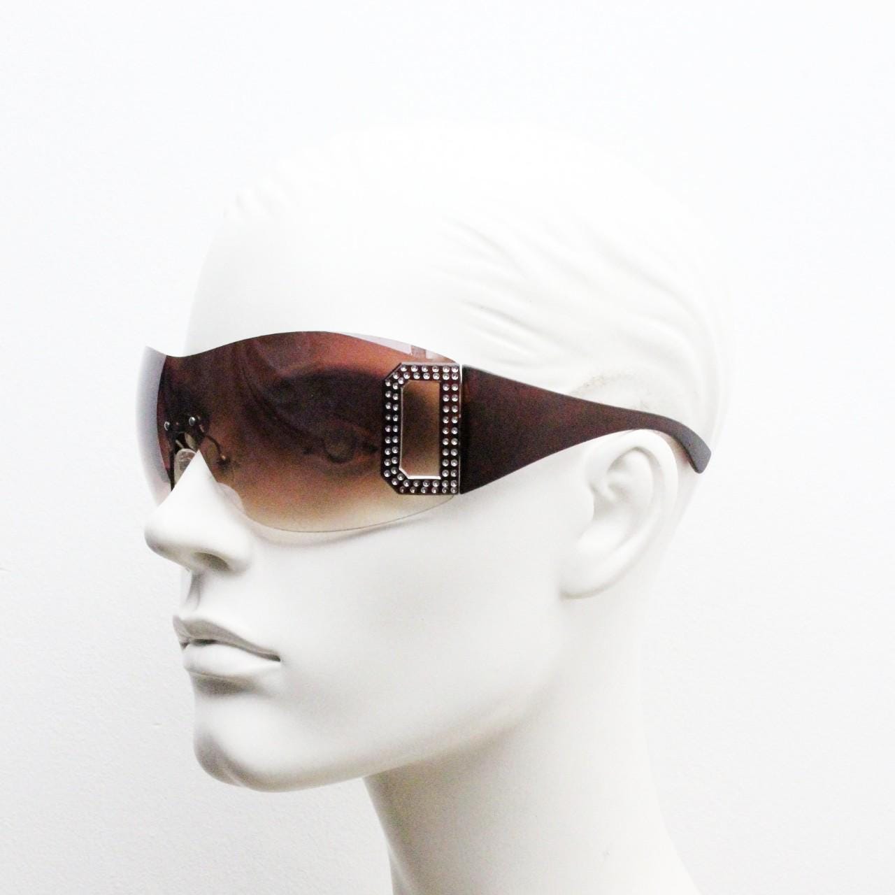 Y2K vintage visor sunglasses. 2000's brown wraparound mono lens shield design with big diamante effect crest. 00s uber fashion mini mask NOS